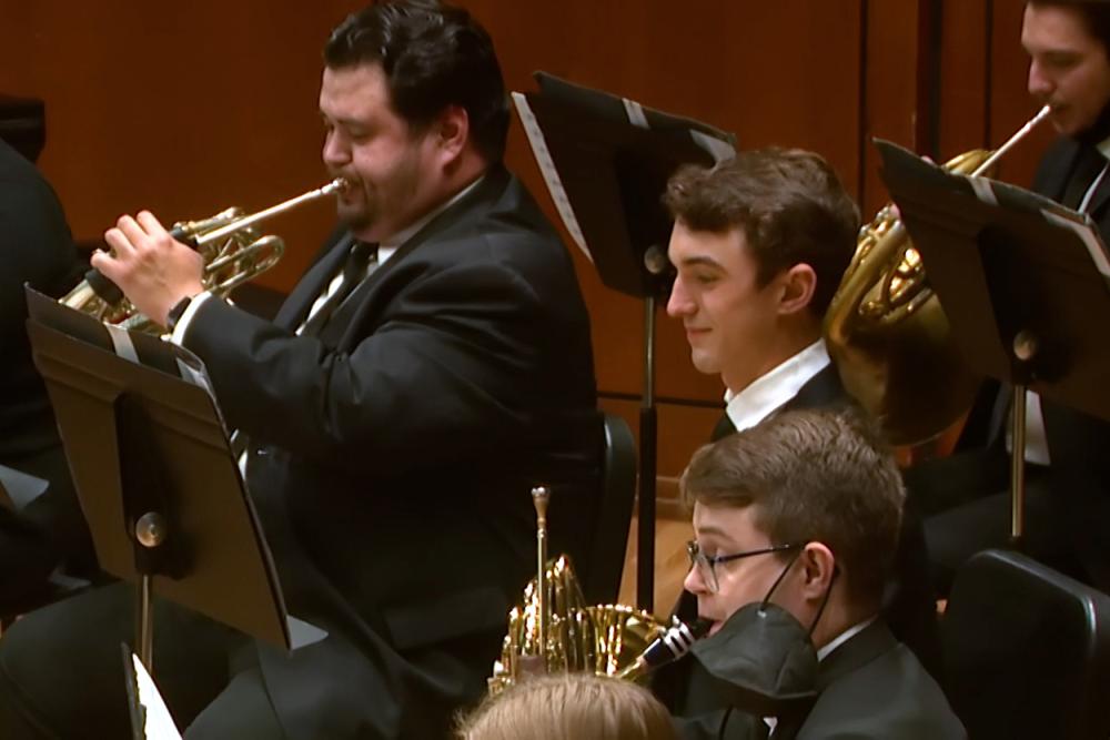 three people playing the horn in a concert