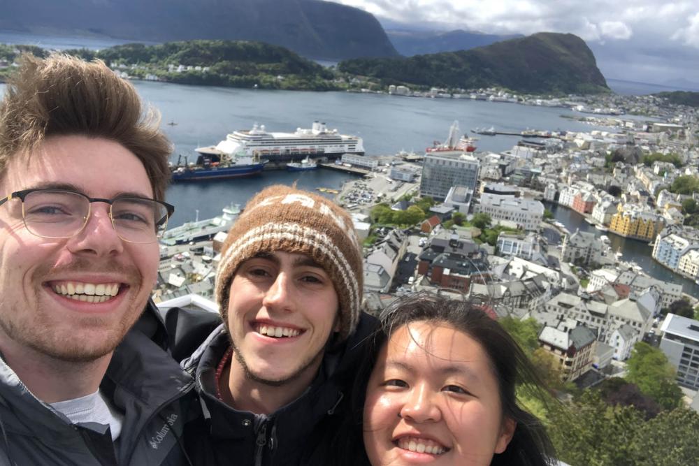 3 friends with a ship behind them