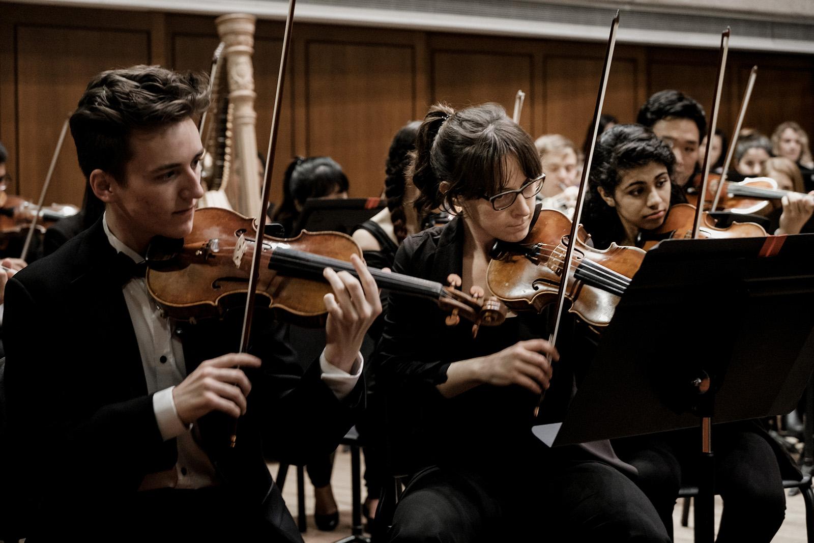 Symphony Orchestra violinists performing in Bates Recital Hall