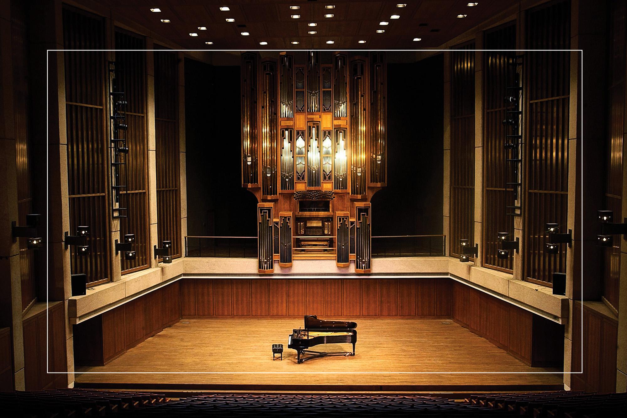 A piano sits on the Bates Recital Hall stage, ready for a performance.