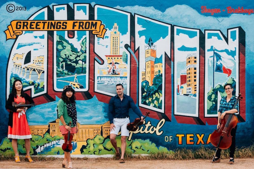A group of Butler students hang out in front of a wall mural that reads "welcome to Austin"