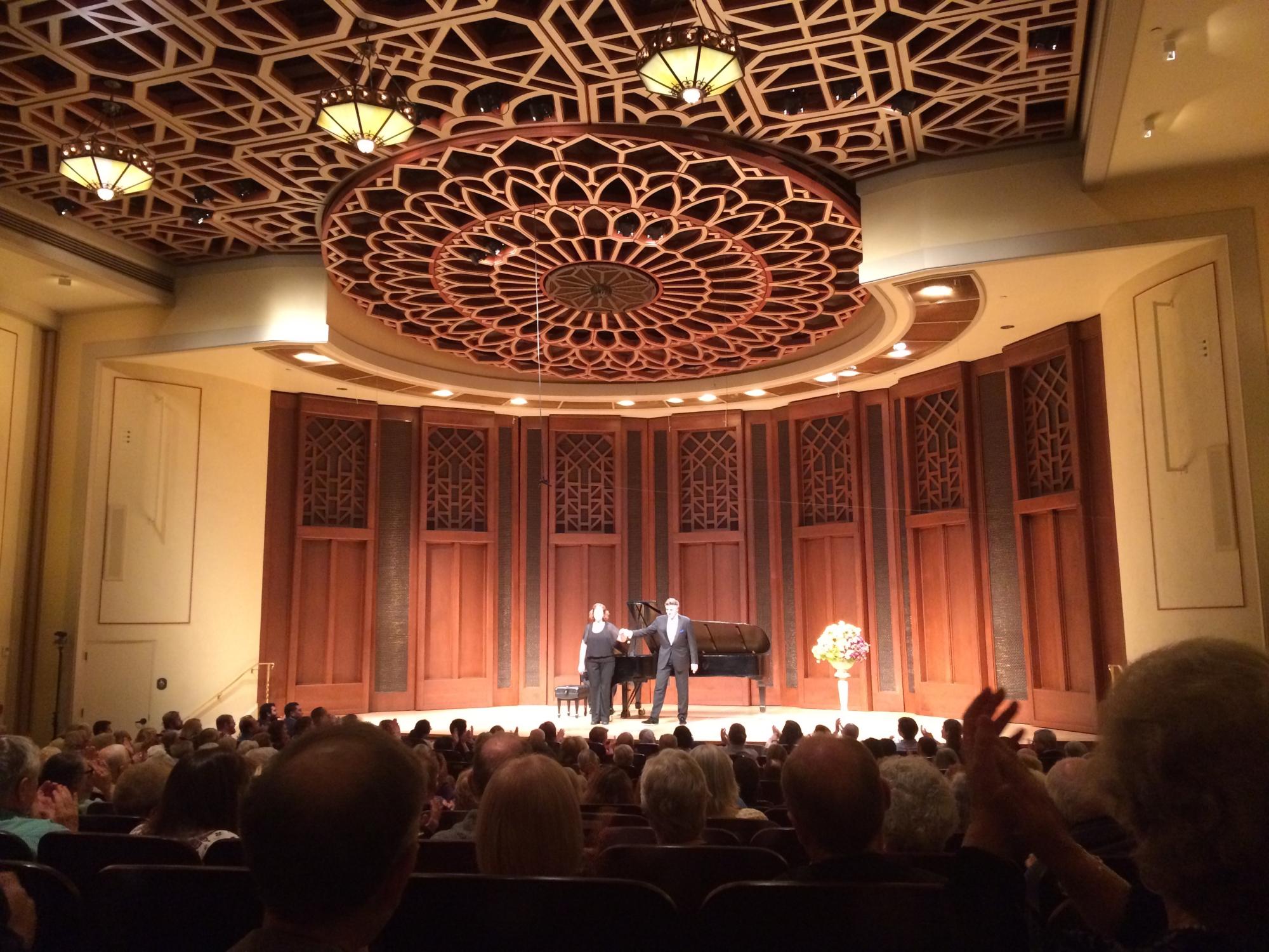 The audience watches performers on stage at the Butler Opera Center