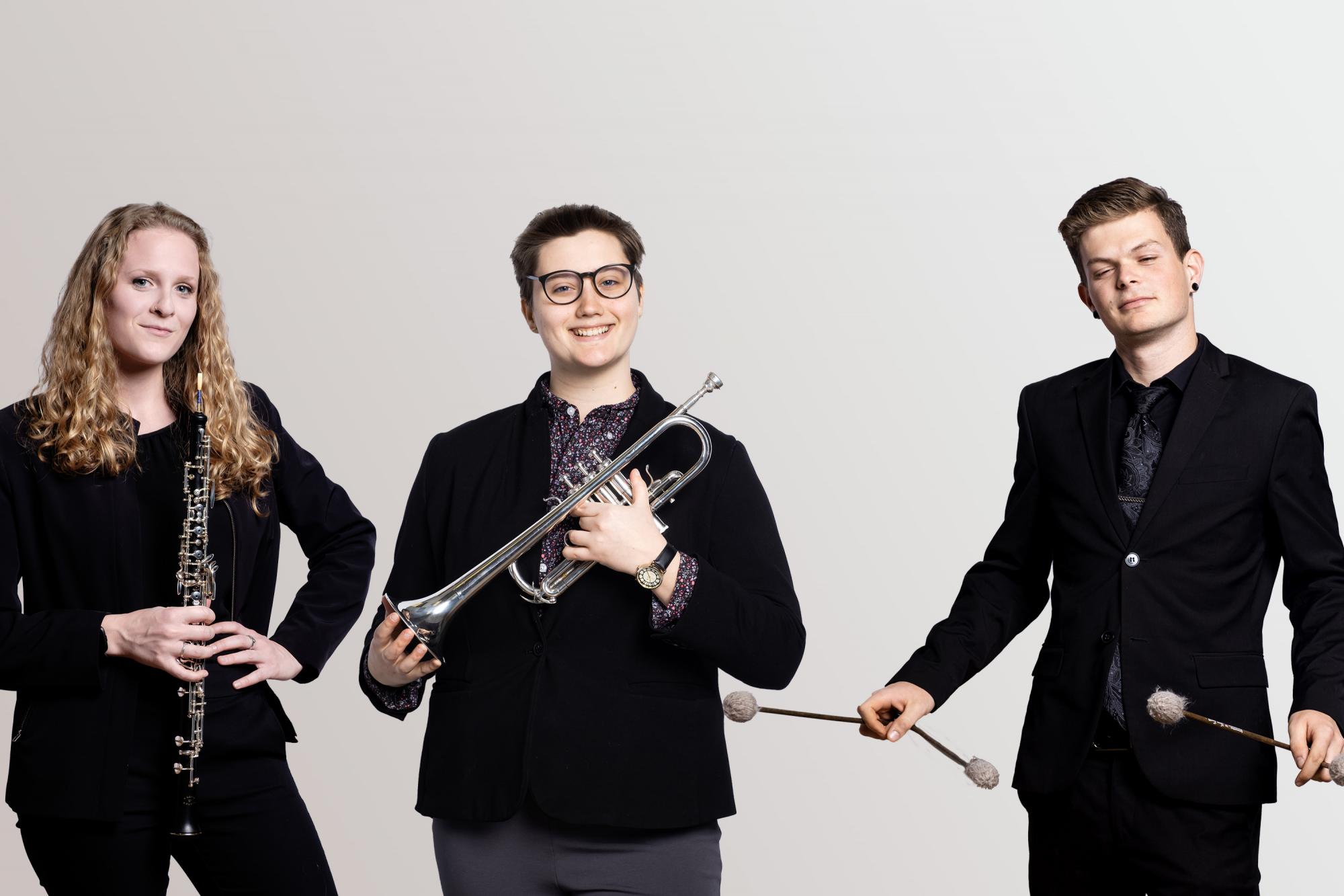 an oboe player, trumpet player, and a marimba player with mallets. 