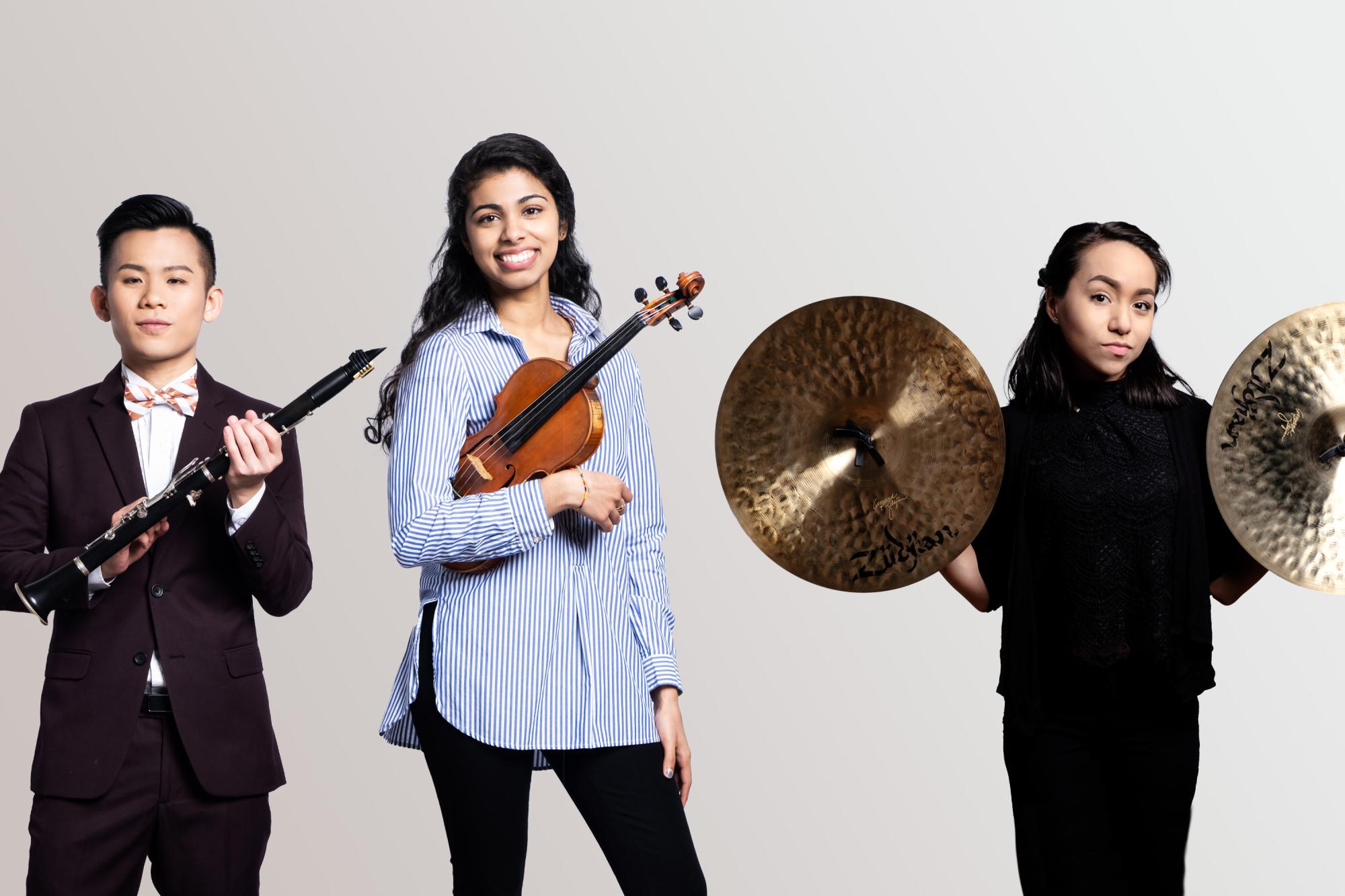 a clarinet player, violinist, and cymbals player poser for the camera