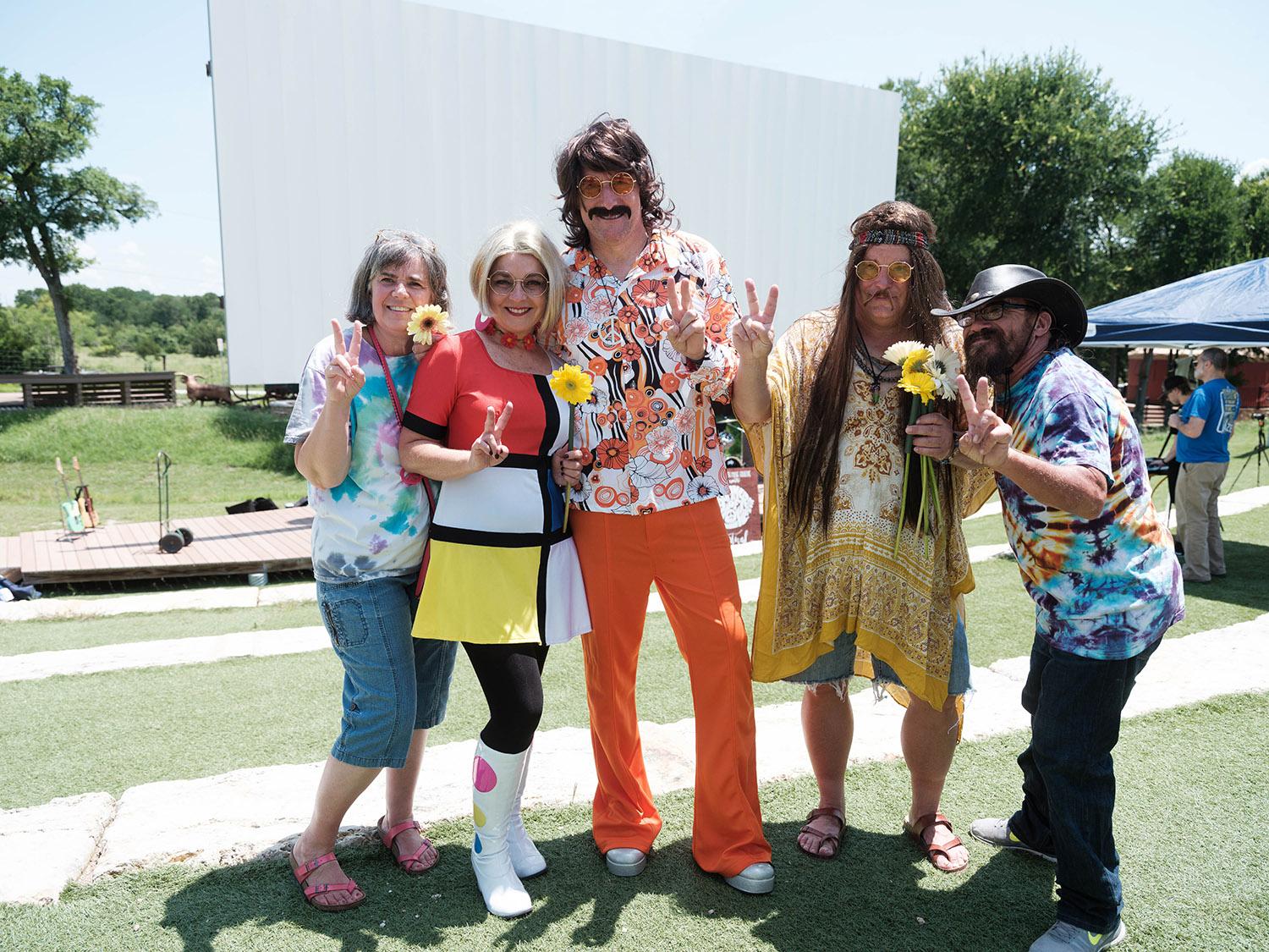 A group of concert goers dressed up in their best Summer of Love 60s apparel