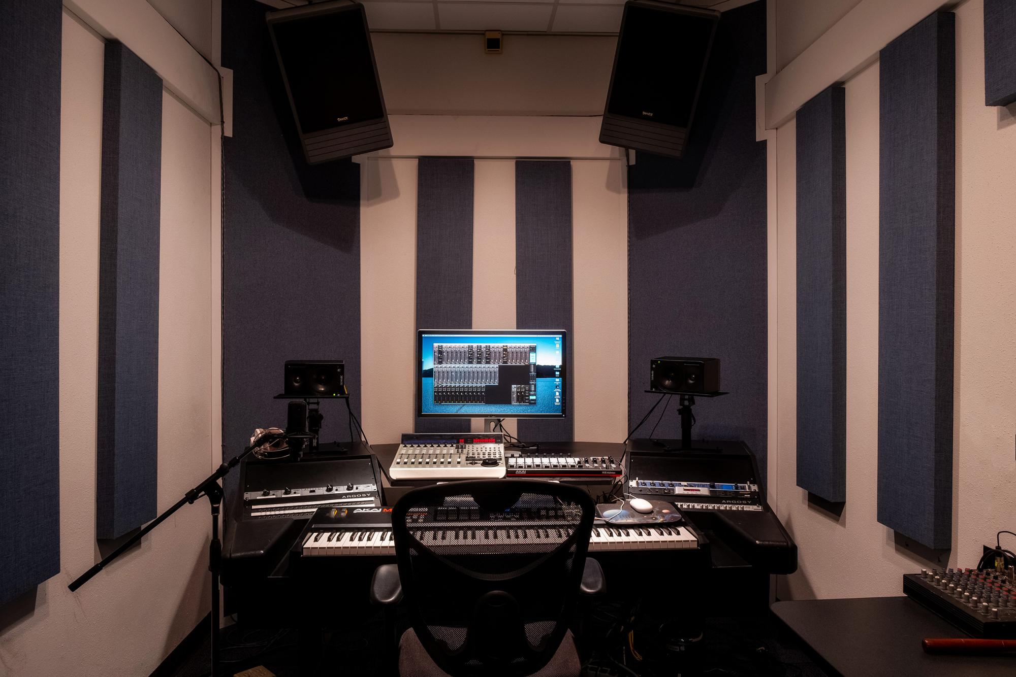 A room with acoustic tiles and a large electronic music workstation