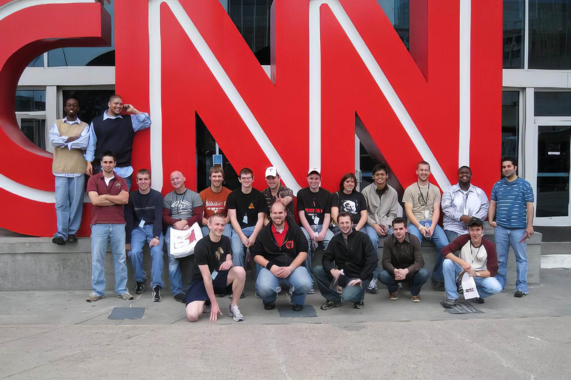 Trombone choir poses at the CNN sign at CNN headquarters in atlanta