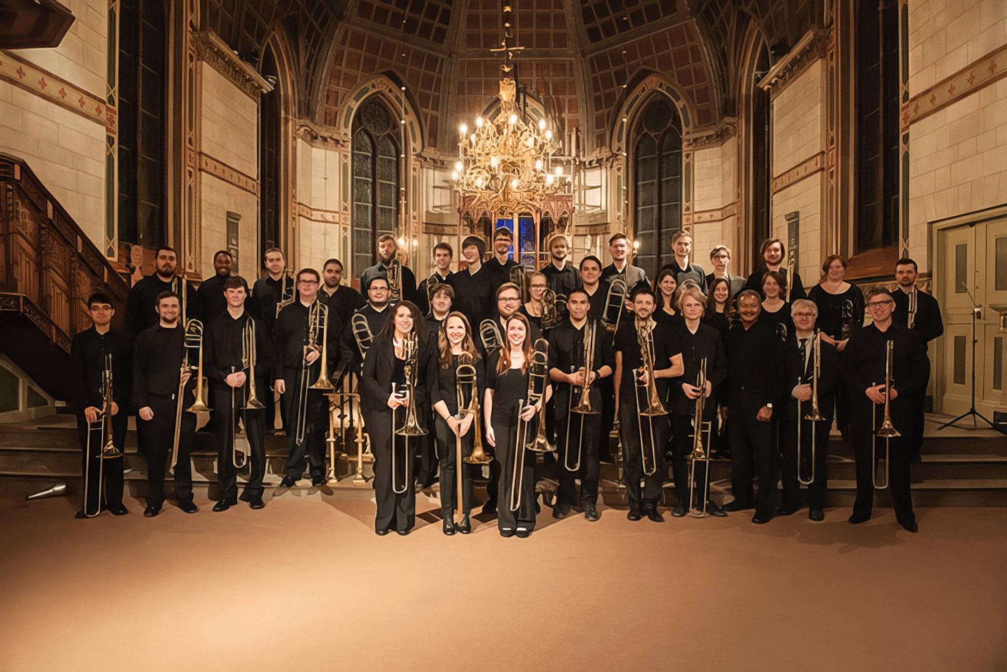 Trombone Choir poses for a photo in an ornate cathedral