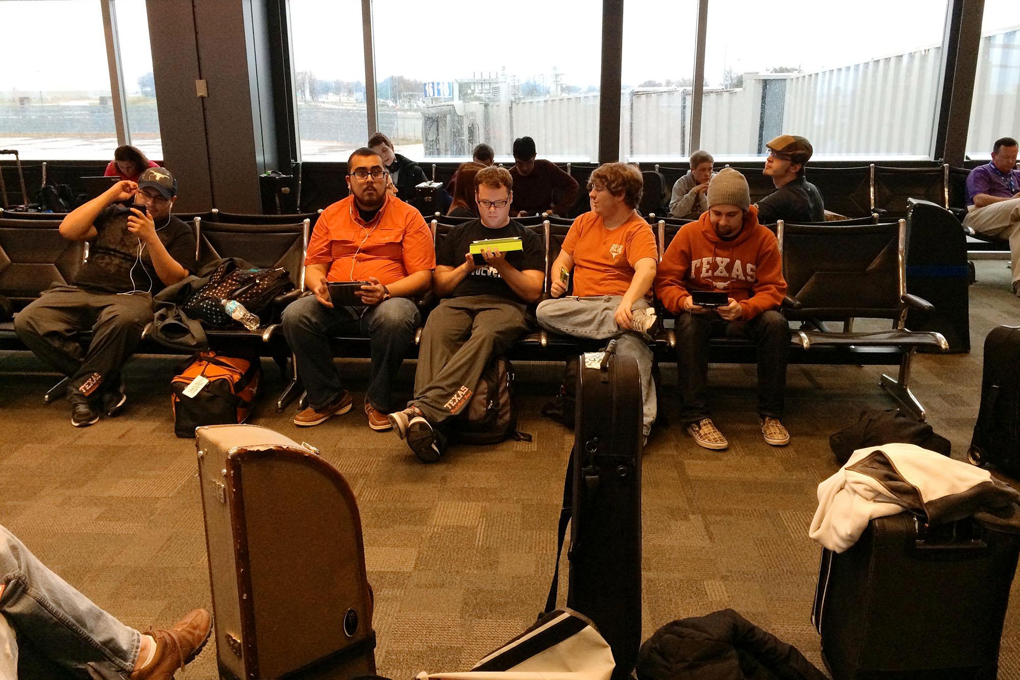 members of trombone choir lounging in the the Austin Airport