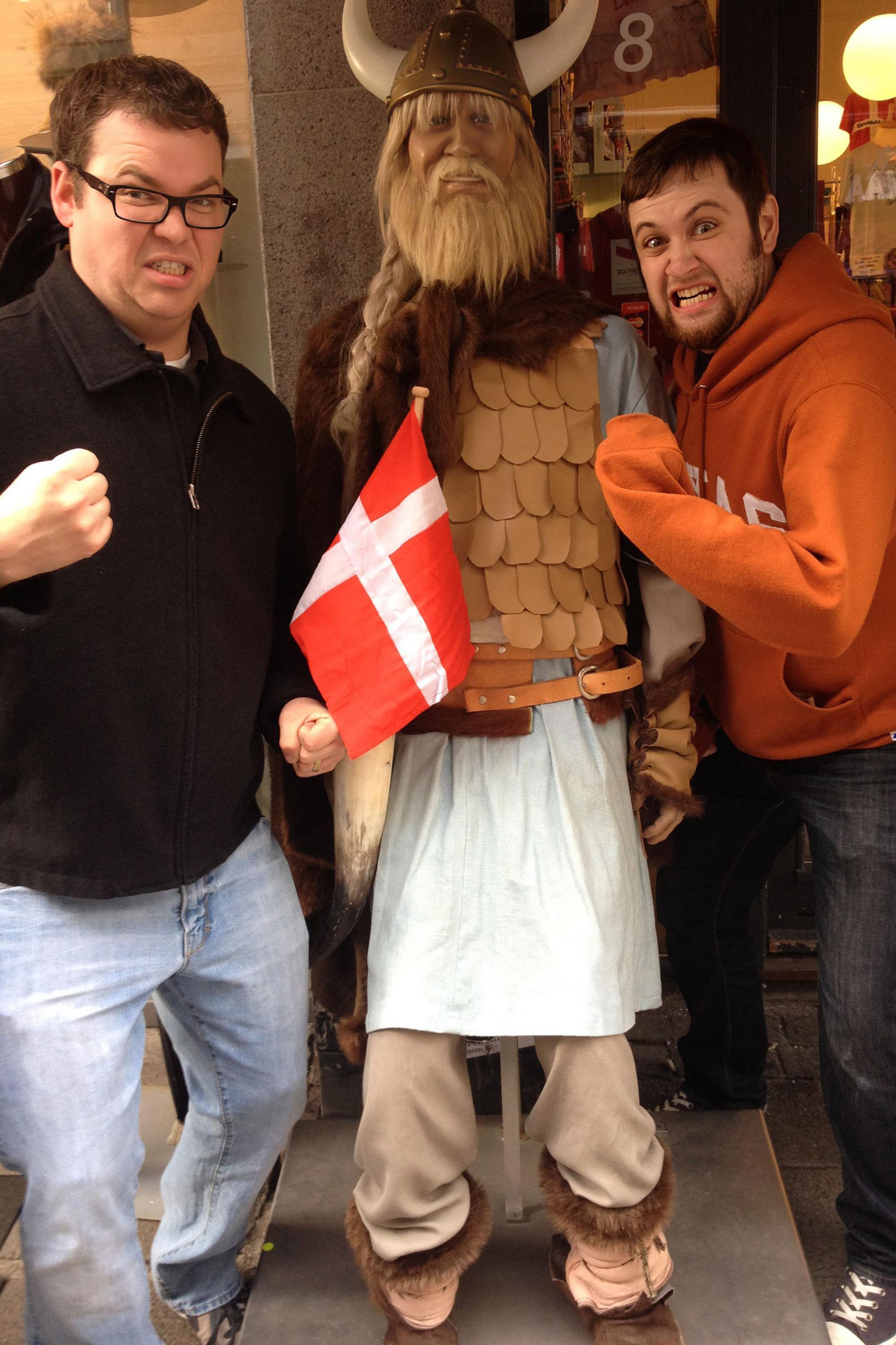 Two students pose with a life-sized figurine of a viking