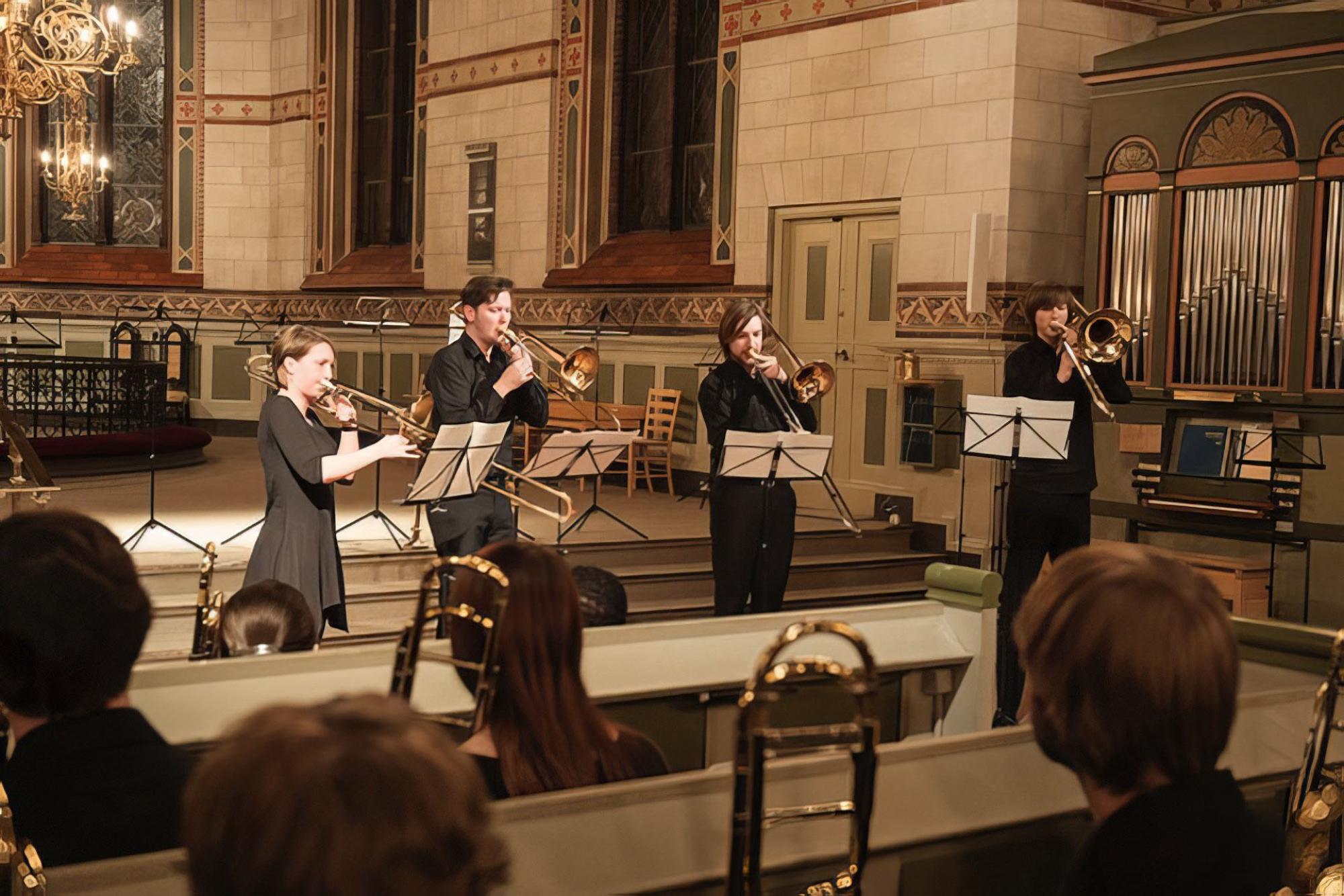 trombone choir performs in an ornate European cathedral