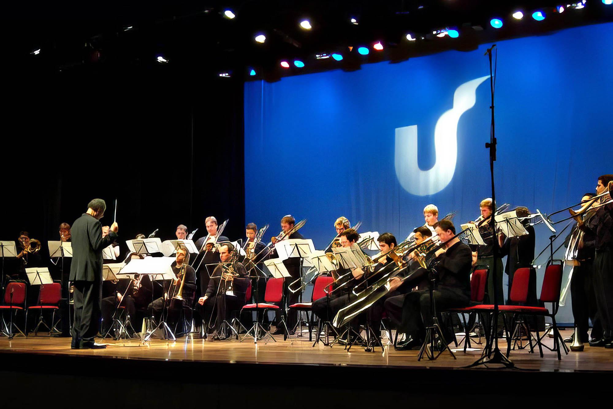 Nathaniel Brickens conducts the trombone choir on stage at a performance in Brazil 