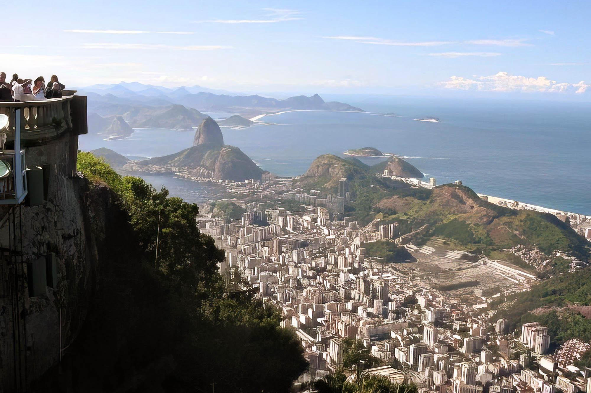 Students look out at a scenic view of Rio de Janeiro below them, with a clear view of the Atlantic Ocean