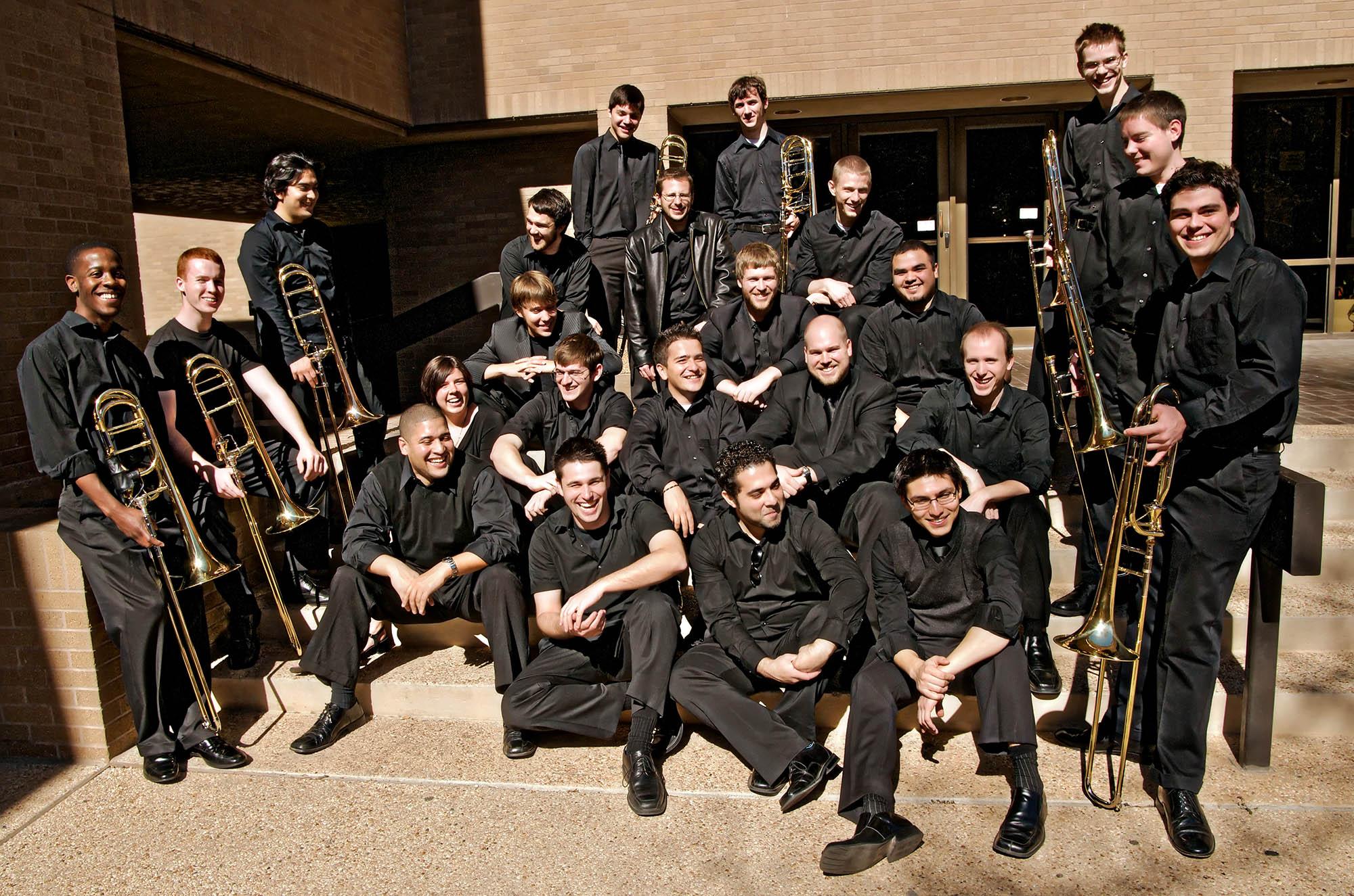 the 2009 trombone choir pose for a casual photo outside of the Music Recital Hall building on the University Campus