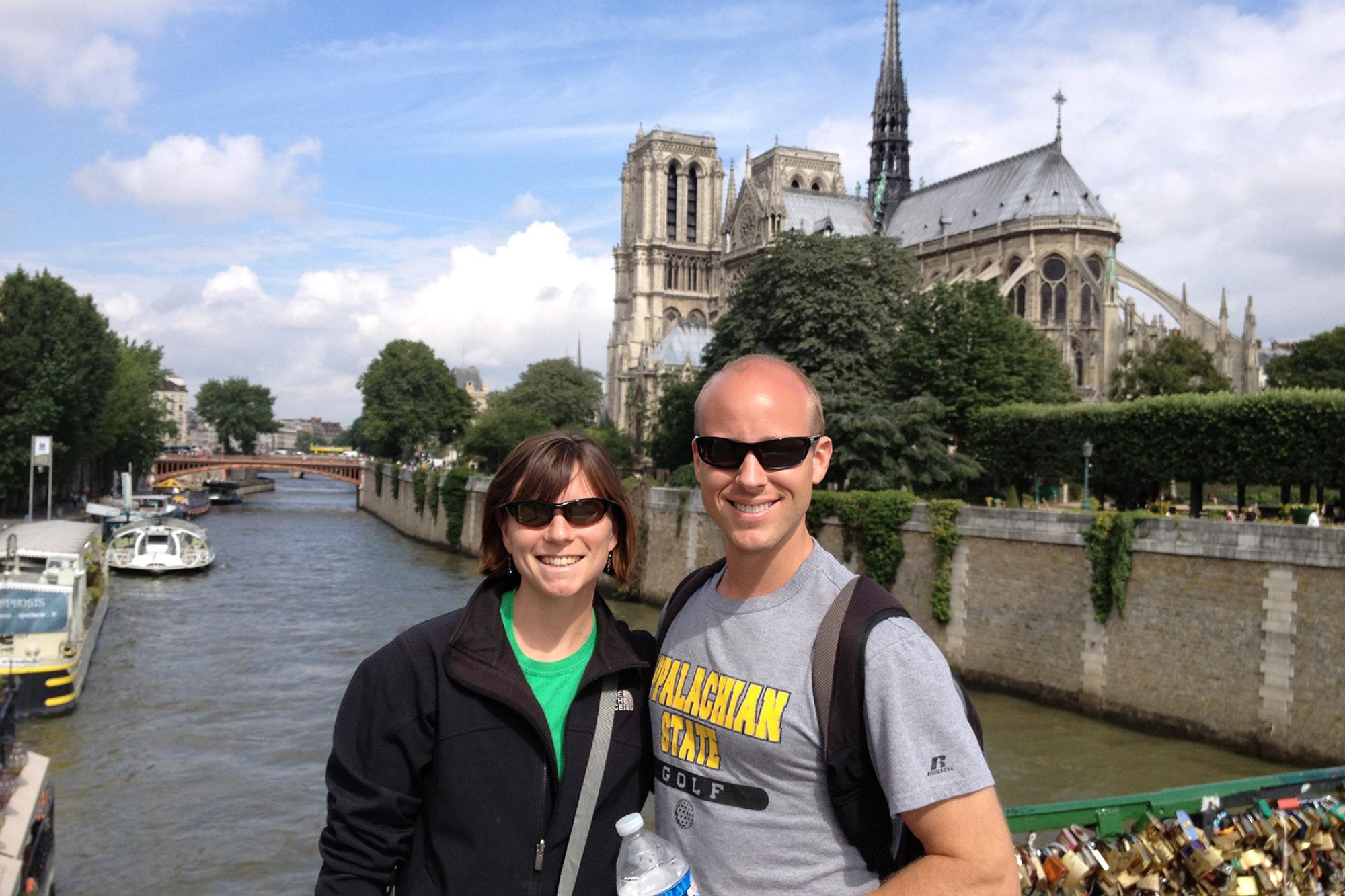 two trombone students pose in front of Notre Dame Cathedral