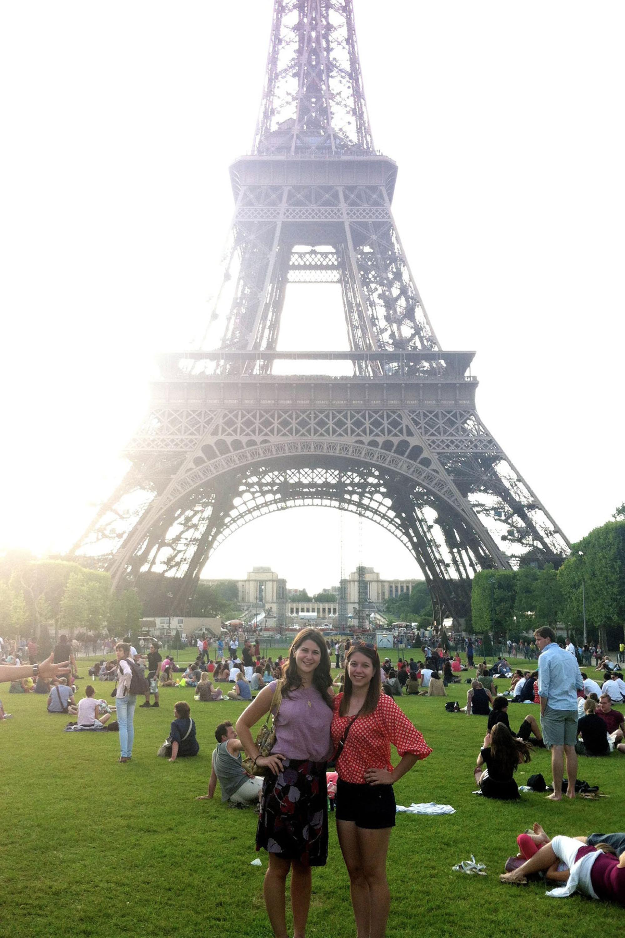 two students pose on the lawn in front of the Eiffel Tower