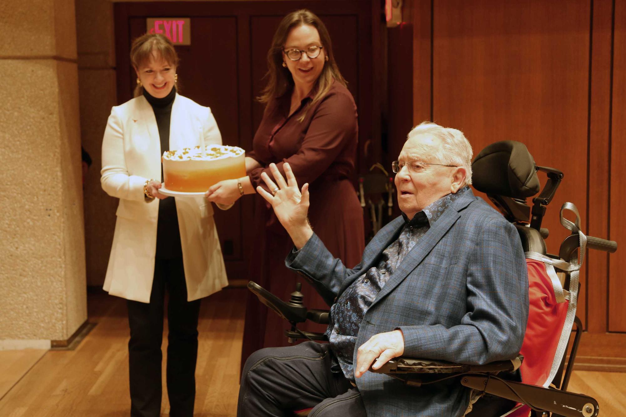 Joe Long waving to the crowd while getting a birthday cake onstage