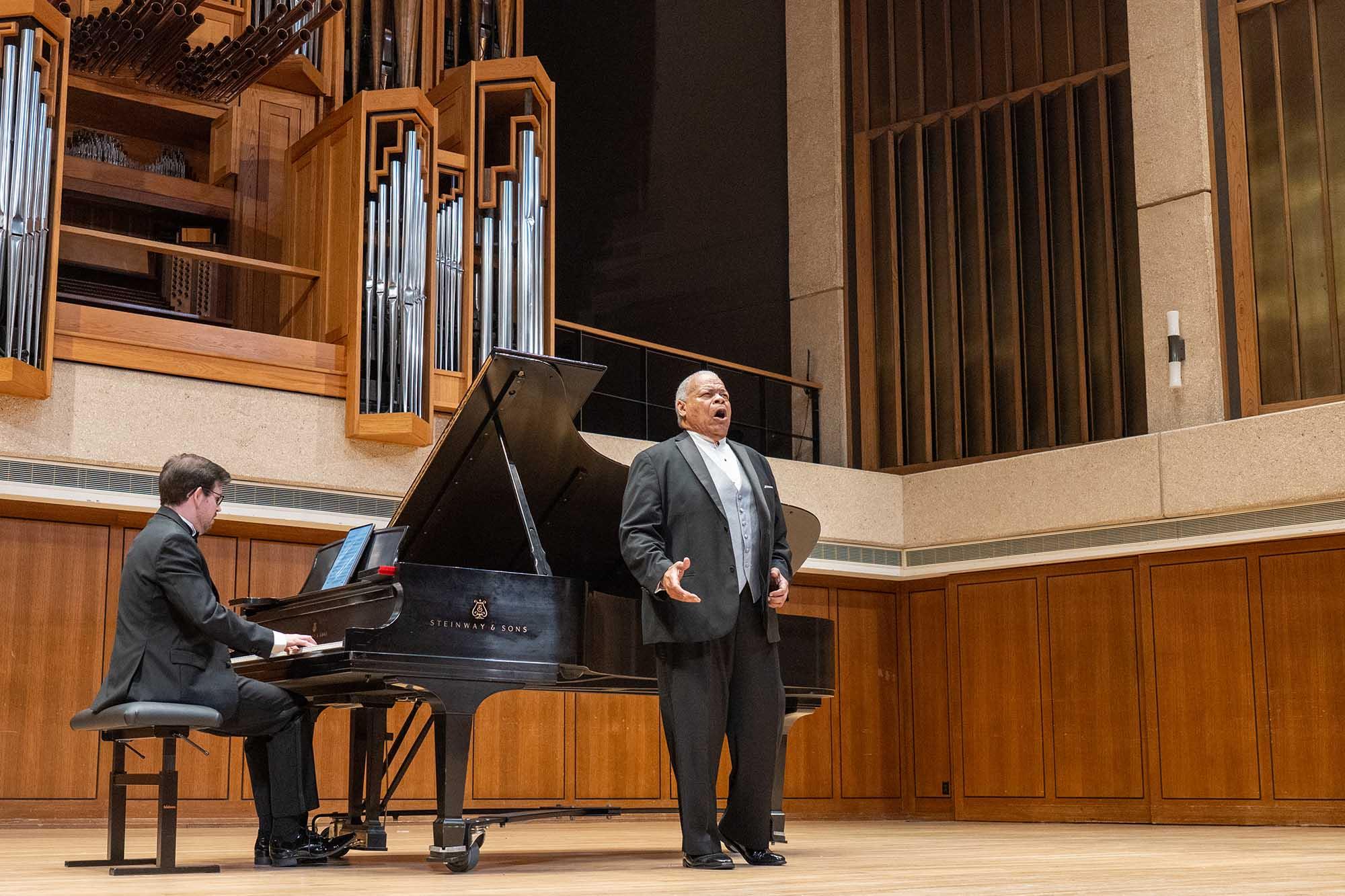 Donnie Albert Singing on Stage in front of a piano