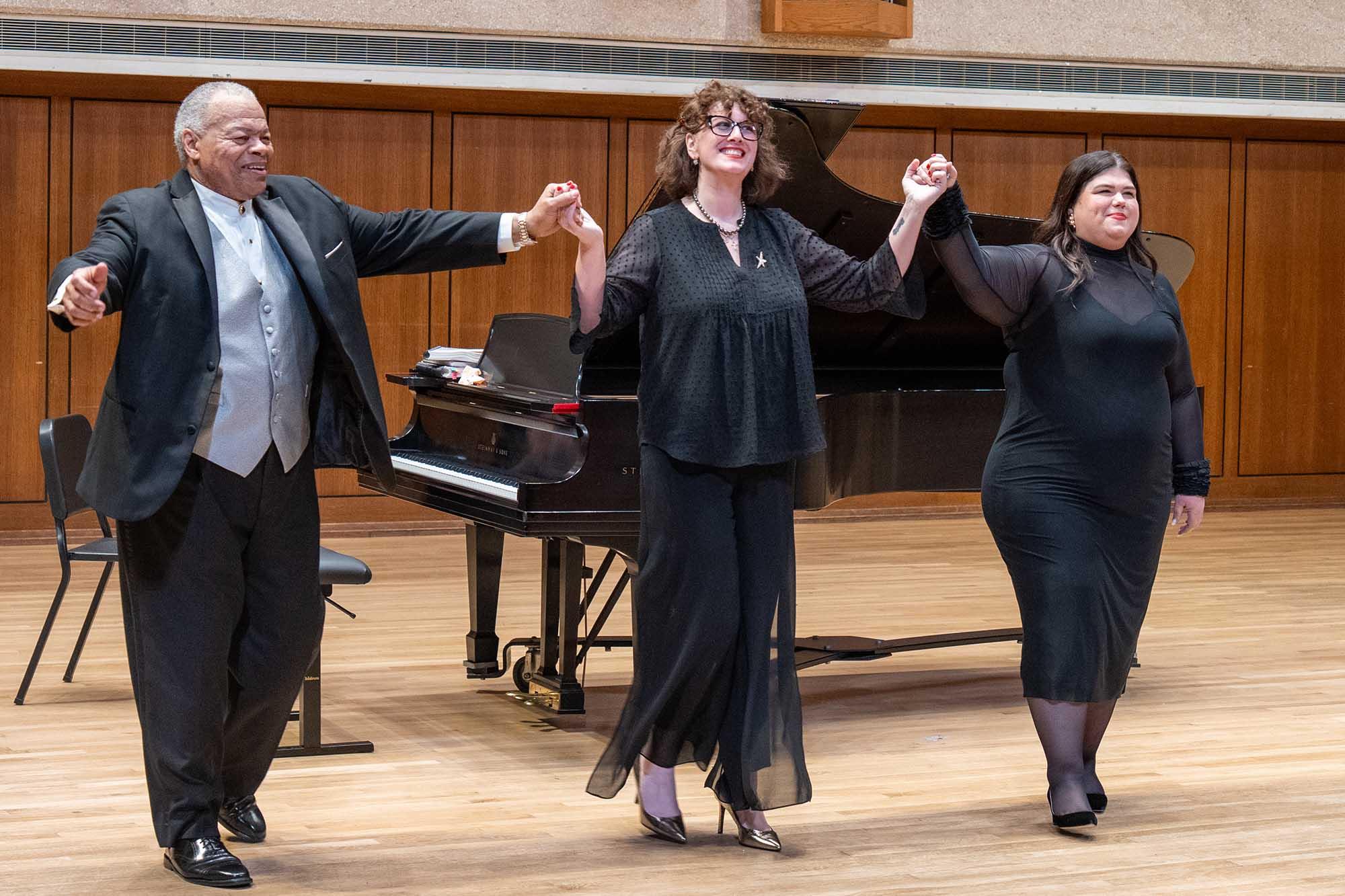 Three people taking a bow on stage