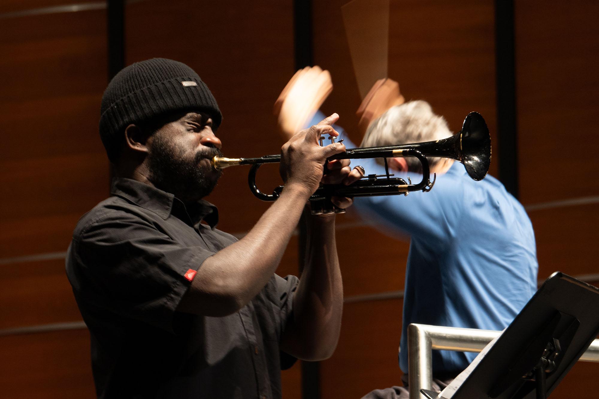 Giveton Gelin plays the trumpet with conductor Peter Bay in the background