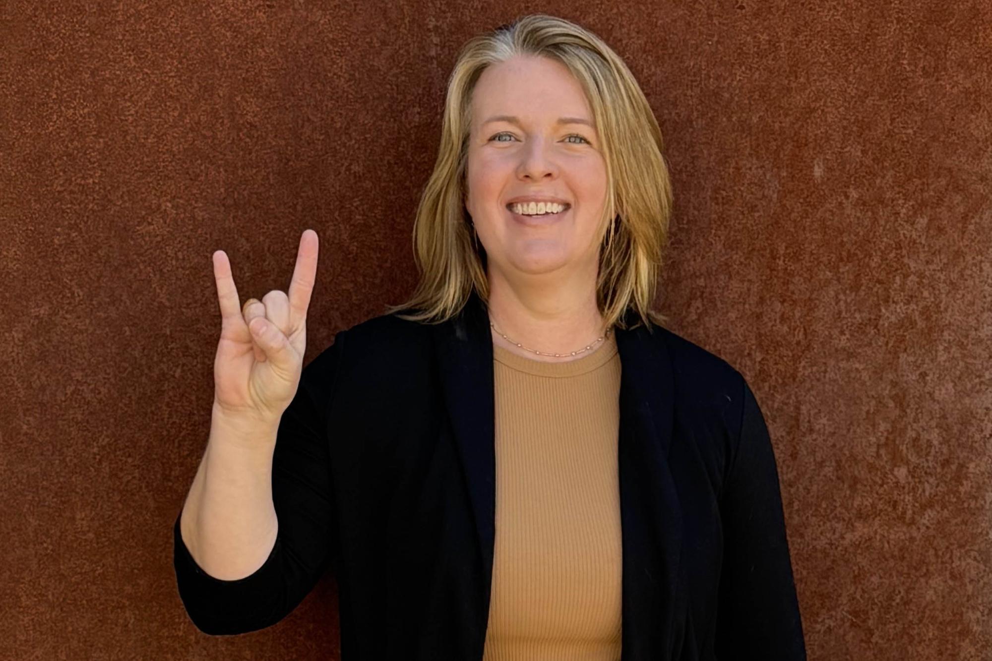 Holly Dalrymple showing the hook em sign