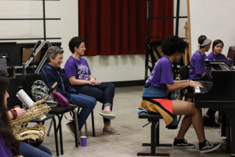 student performs on piano as others listen as part of the Jazz Girls TX project