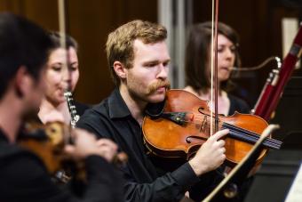Male violinist performs with New Music Ensemble in Bates Recital Hall