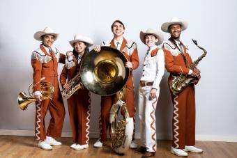 Smiling members of longhorn band pose with instruments