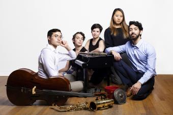 Members of New Music ensemble pose with instruments and a toy piano