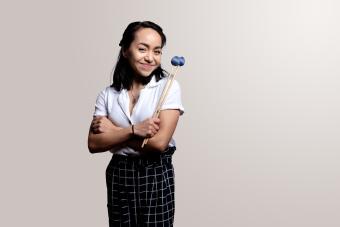 Percussions with her mallets smiling at the camera