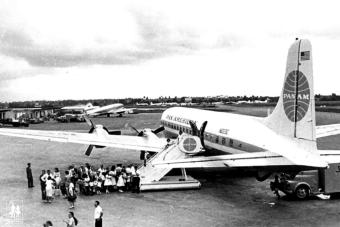 Black and white archival image of people getting on plane