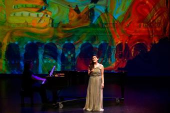 Mezzo soprano Talin Nalbandian singing in front of a watercolor background.