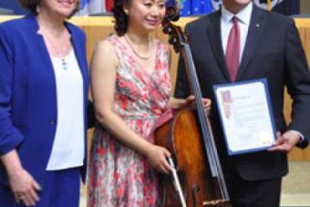 Hai Zheng with her cello and accompanied by Austin Mayor Steve Adler and city council member 