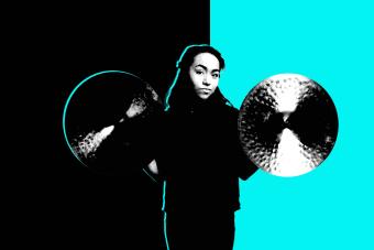 a student percussionist holds up a pair of cymbals