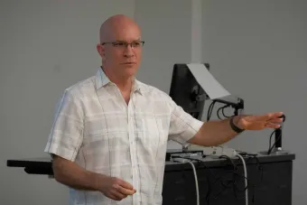 Robin Moore talking with a computer in background