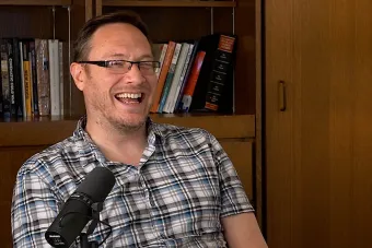 Andrew Parker laughing in front of a bookcase