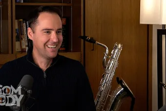 Stephen Page sitting in an office with a Sax behind him