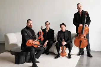 Miro Quartet sitting on a couch in front of a white wall