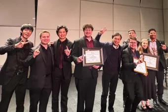 Members of the Zed and 4116 quartet standing on stage celebrating their victory
