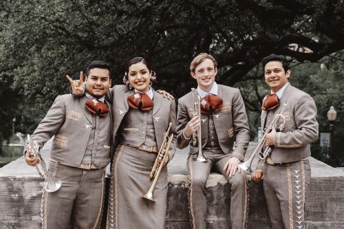 Mariachi Trumpets looking into camera and making  Hook 'em horns