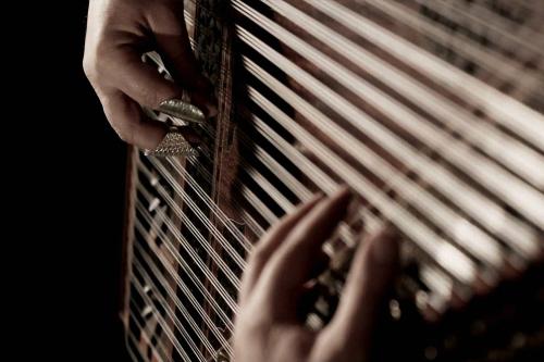 Close up photo of hands playing a qanun