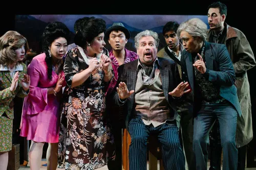 a Group of enthralled spectators gather around an old man telling a dramatic story.
