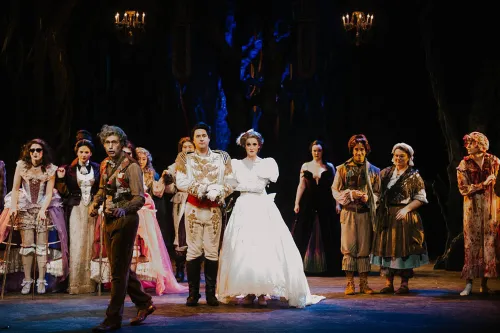 the Cast of into the woods stand on stage, ready for the curtain call