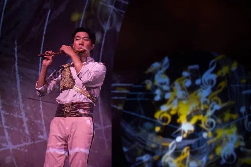 a man dress in a stately white uniform performs on his flute.