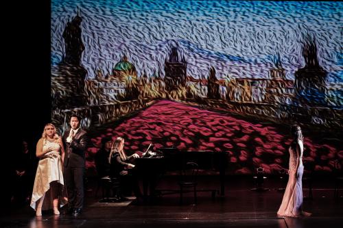 three singers perform on stage in front of a projection of a an expressionist field of poppies.