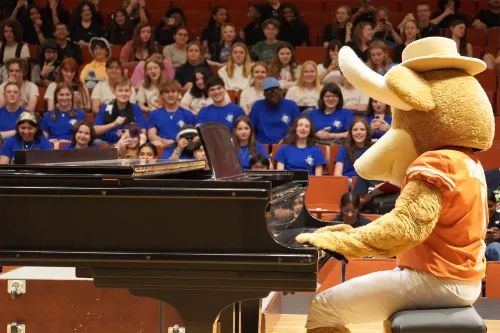 Hook'Em playing piano in front of an audience