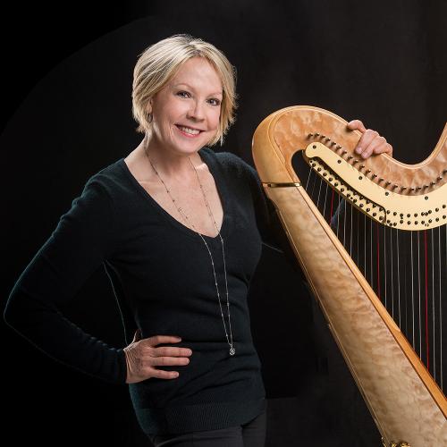 Delaine Leonard poses with a harp