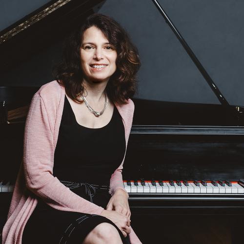 Pattie Wolf sits at a Piano 