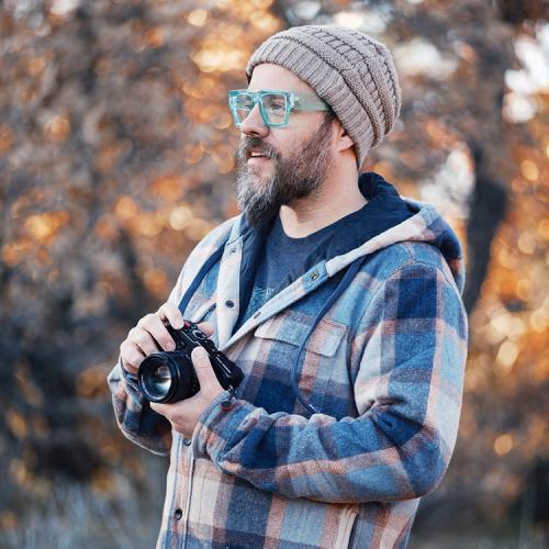 A Portrait of Nathan Russell holding a camera