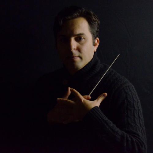 Professor Farkhad Khudyev holds his conducting baton and looks into camera